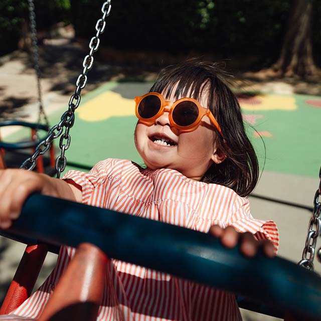 Girl smiling while swinging on a playset